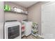 Laundry room with a washer, dryer, storage, and tile floors at 11224 Amber Glen Dr, Charlotte, NC 28269