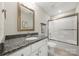 Bathroom showcasing granite countertop, framed mirror, and a shower with glass doors at 11249 Island View Ln, Lancaster, SC 29720