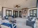 Relaxing covered patio with a stone fireplace, ceiling fan, and comfortable seating area at 11249 Island View Ln, Lancaster, SC 29720