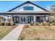 Inviting covered porch with stone pillars, manicured landscaping, and elegant black-framed windows at 11249 Island View Ln, Lancaster, SC 29720