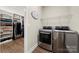 Bright laundry room featuring stainless steel washer and dryer, with built in shelving and closet storage at 11249 Island View Ln, Lancaster, SC 29720
