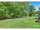 A large backyard with green grass, mature trees, and a small outbuilding at 130 Helen Dr, Statesville, NC 28625