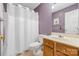 A full bathroom with purple walls, shower with white curtain, and wooden sink vanity at 130 Helen Dr, Statesville, NC 28625