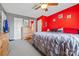 A primary bedroom with a bright red accent wall, ceiling fan and cozy bedding at 130 Helen Dr, Statesville, NC 28625