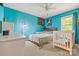 A bedroom with bright blue walls, ceiling fan, and bed with wooden headboard at 130 Helen Dr, Statesville, NC 28625