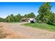 Exterior view of home featuring long gravel driveway, windmill and a trailer at 130 Helen Dr, Statesville, NC 28625