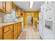 Bright kitchen featuring wood cabinets, tiled floor, and white appliances at 130 Helen Dr, Statesville, NC 28625