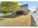Spacious backyard with green grass, mature tree, and a white picket fence at 13502 Brandon Trail Dr, Charlotte, NC 28213