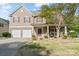 Traditional two-story home featuring stone accents, a covered porch, and a well-maintained lawn at 13502 Brandon Trail Dr, Charlotte, NC 28213