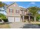 Charming two-story home with stone accents, red shutters, and a two-car garage at 13502 Brandon Trail Dr, Charlotte, NC 28213