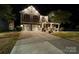 Beautifully lit two-story home featuring a two-car garage, a large driveway, and manicured lawn at 13502 Brandon Trail Dr, Charlotte, NC 28213