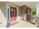 Inviting front porch with stone columns and cozy rocking chairs by a wood and glass front door at 13502 Brandon Trail Dr, Charlotte, NC 28213