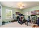 Home gym featuring a treadmill, weights, and an exercise area, with bright light at 13502 Brandon Trail Dr, Charlotte, NC 28213