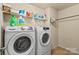 Functional laundry room featuring a washer, dryer, and shelving for storage at 13502 Brandon Trail Dr, Charlotte, NC 28213