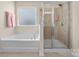 Elegant bathroom with a soaking tub and glass-enclosed shower, providing a spa-like experience at 137 Sugar Magnolia Dr, Mooresville, NC 28115