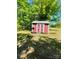 Red shed with an overgrown lawn and a small step leading up to the door at 143 Greenville Blvd, Bessemer City, NC 28016