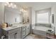 Bright bathroom with double vanity, a soaking tub, and modern fixtures, creating a serene and spa-like experience at 15622 Little Bluestem St, Charlotte, NC 28278