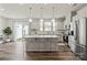 Modern kitchen with white cabinets, stainless steel appliances, a large island, and a sliding glass door to the patio at 15622 Little Bluestem St, Charlotte, NC 28278