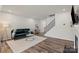 Comfortable living room featuring hardwood floors, a sofa, and a staircase leading to the second floor at 15622 Little Bluestem St, Charlotte, NC 28278