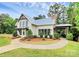 Charming home with a manicured lawn, a stone chimney, complemented by lush landscaping and a welcoming walkway at 16012 Tulloch Rd, Charlotte, NC 28278