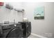A bright laundry room with modern appliances and shelving for storage at 16012 Tulloch Rd, Charlotte, NC 28278