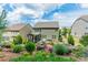 Picturesque backyard view featuring a screened porch, patio, and lush landscaping, set against a backdrop of neighboring homes at 16507 Palisades Commons Dr, Charlotte, NC 28278