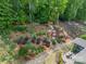 A lush backyard with terraced landscaping, a stone pathway, and a patio area with outdoor seating at 16507 Palisades Commons Dr, Charlotte, NC 28278