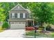 Charming two-story home with a well-manicured lawn, colorful flowers, and a two-car garage at 16507 Palisades Commons Dr, Charlotte, NC 28278