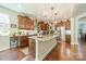 Spacious kitchen featuring a granite island with pendant lights, wooden cabinets, and stainless steel appliances, enhanced by hardwood floors at 16507 Palisades Commons Dr, Charlotte, NC 28278