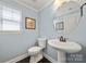 Powder room featuring a pedestal sink, decorative mirror, and classic design at 199 Blossom Ridge Dr, Mooresville, NC 28117