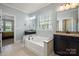 Light-filled bathroom features a soaking tub, separate vanities, and tile flooring at 199 Blossom Ridge Dr, Mooresville, NC 28117