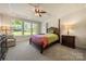 Elegant bedroom with a four-poster bed, tray ceiling, and bright natural light at 199 Blossom Ridge Dr, Mooresville, NC 28117