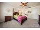 Charming bedroom featuring a four-poster bed, ceiling fan, and decorative mirror at 199 Blossom Ridge Dr, Mooresville, NC 28117