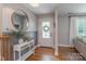 Inviting foyer with hardwood floors, stylish console table, round mirror and a front door with glass detailing at 2009 Edgewater Dr, Charlotte, NC 28210