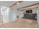 Open-concept living room featuring a fireplace, wooden beams, and wood flooring at 2009 Edgewater Dr, Charlotte, NC 28210
