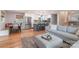 Open-concept living space with a gray sofa, dining area, kitchen, and hardwood floors at 2009 Edgewater Dr, Charlotte, NC 28210