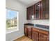 Butler's pantry with dark wood cabinets, granite countertop, and window offering natural light, blending functionality and style at 2151 Belle Vernon Ave, Charlotte, NC 28210