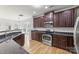 Well-appointed kitchen with stainless steel appliances, dark wood cabinetry, and granite countertops, perfect for cooking and entertaining at 2151 Belle Vernon Ave, Charlotte, NC 28210