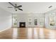 Bright living room with fireplace, hardwood floors, and many windows letting in natural light and a ceiling fan at 2151 Belle Vernon Ave, Charlotte, NC 28210