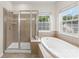 Relaxing soaking tub and separate glass shower in the main bathroom at 2151 Belle Vernon Ave, Charlotte, NC 28210