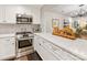 Bright kitchen showcasing stainless steel appliances, white countertops, and a pass-through to the living room at 2719 Selwyn Ave # 20, Charlotte, NC 28209