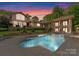 Beautiful backyard pool with a stone surround, lounge chairs and a covered patio at 2915 Cutter Ct, Waxhaw, NC 28173