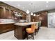 Gorgeous kitchen featuring custom cabinetry, stone wall accents, an island with bar seating, and stainless appliances at 2915 Cutter Ct, Waxhaw, NC 28173