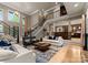 Open-concept living room featuring a staircase, bar area, and plenty of natural light at 2915 Cutter Ct, Waxhaw, NC 28173
