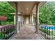 Covered porch with tile flooring, decorative pillars, and railing with a pool and garden in view at 2915 Cutter Ct, Waxhaw, NC 28173