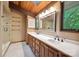Bathroom featuring double sinks, a walk-in shower, wood-trimmed mirror, and a skylight at 3165 Laurel Ridge Nw Rd, Hickory, NC 28601
