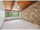 Bright bedroom featuring a wood ceiling, stone wall, and large windows offering scenic views at 3165 Laurel Ridge Nw Rd, Hickory, NC 28601