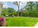 Expansive backyard featuring manicured lawn, mature trees, and umbrella-shaded seating at 331 Anthony Cir, Charlotte, NC 28211