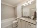 Modern bathroom with a combined tub and shower, sleek vanity, and contemporary lighting fixtures at 331 Anthony Cir, Charlotte, NC 28211