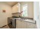 Functional laundry room equipped with a modern washer, dryer, sink and storage at 331 Anthony Cir, Charlotte, NC 28211